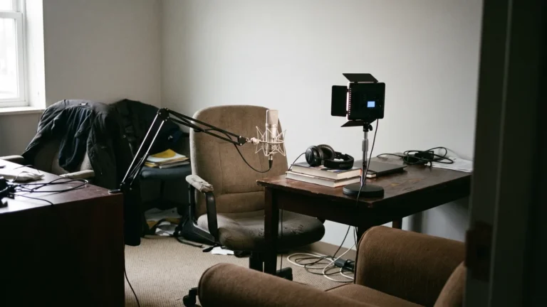 Small meeting room set up with microphone on boom arm, headphones and a single LED light