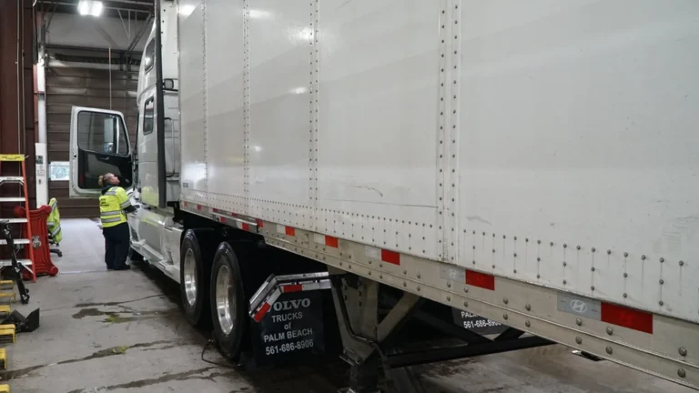 Truck driver checking a tractor-trailer in a freight yard, the daily reality behind DOT compliance training
