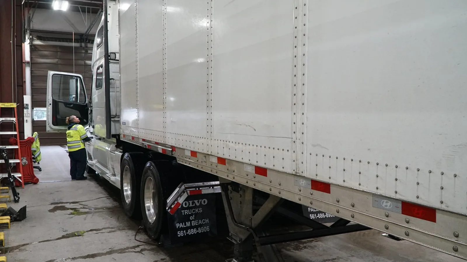 Truck driver checking a tractor-trailer in a freight yard, the daily reality behind DOT compliance training