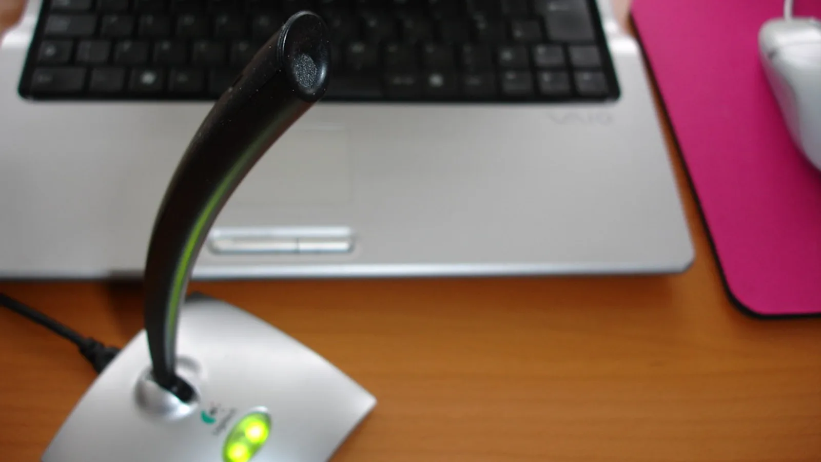 Desk microphone and headset set up for recording a training walkthrough in an office